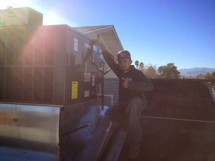 HVAC technician performing AC Tune-Up on a rooftop unit in McFarland